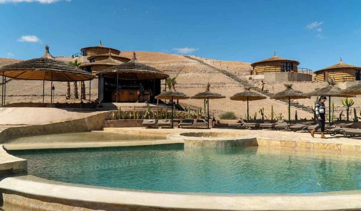 Touristes profitant d’un déjeuner au bord de la piscine dans un camp du désert d’Agafay